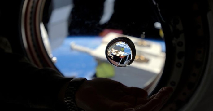 A drop of water floats above Samantha Cristoforetti’s hand in zero gravity, on the ISS. 