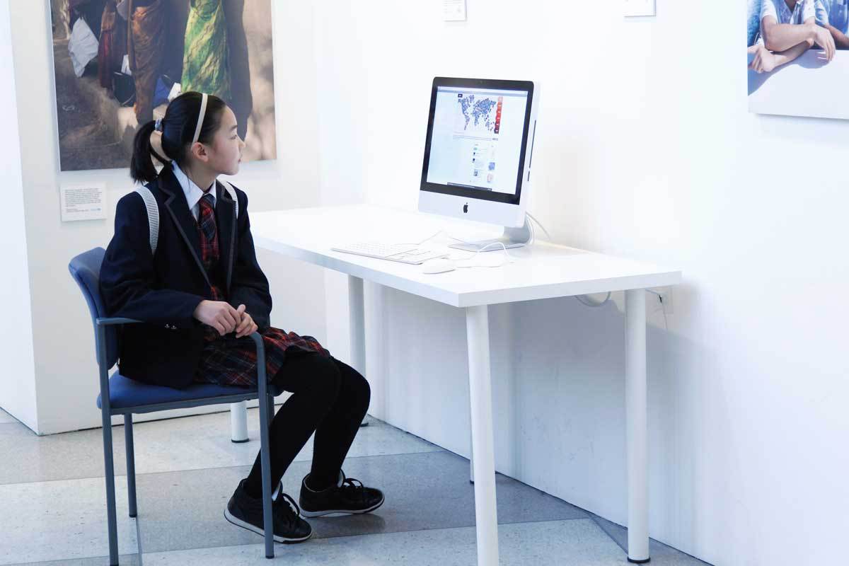 Photo: A girl watches a computer screen in a museum.