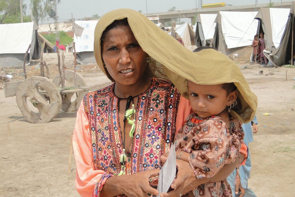 Photo: In Sindh province, Pakistan, a mother tries to shield her four-year-old daughter from scorching heat.