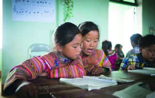 Two 5th graders do their assignment during class at PS La Pan Tan in Viet Nam. Photo: Tuan Nguyen/EFA Report UNESCO