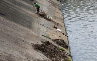 Photo: In Pasig, Philippines, a city worker cleans the Manggahan Floodway, built to reduce flooding along the Pasig River during the rainy season.