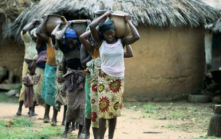 Young women and girls carry water in Nigeria