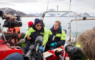 At Norway's high Arctic region, Secretary-General Ban Ki-moon (centre) visits Blomstrandbreen glacier to be briefed by scientists and observe first-hand the advances of climate change since visiting in 2009. Seated to his right is Foreign Minister, Børge Brende of Norway. UN Photo/Rick Bajornas