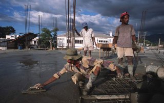 Men at work pouring cement on a rooftop