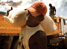 man carrying sack of grain.  Photo: FAO