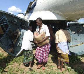 Kenyan men carrying WFP provisions from a helicopter