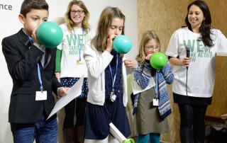 在巴黎气候变化大会，青年们吹起代表地球的气球。气候变化框架公约秘书处图片。