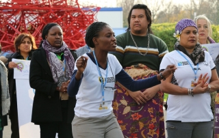 Titi Akosa anime des chants et des danses à la Journée des femmes à la COP21, soulignant la nécessité pour les femmes d’être impliquées dans les négociations sur le climat. Photo Centre d’actualités de l’ONU/Stephanie Coutrix