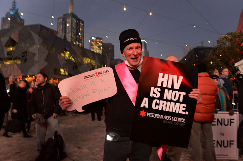 Активит с плакатом «ВИЧ - это не преступление». Фото ЮНЭЙДС
