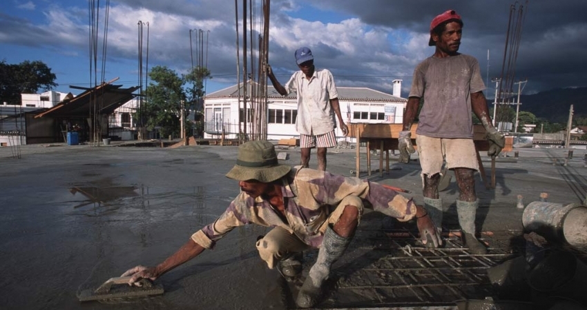 Men at work pouring cement on a rooftop. Photo: World Bank/Alex Baluyut