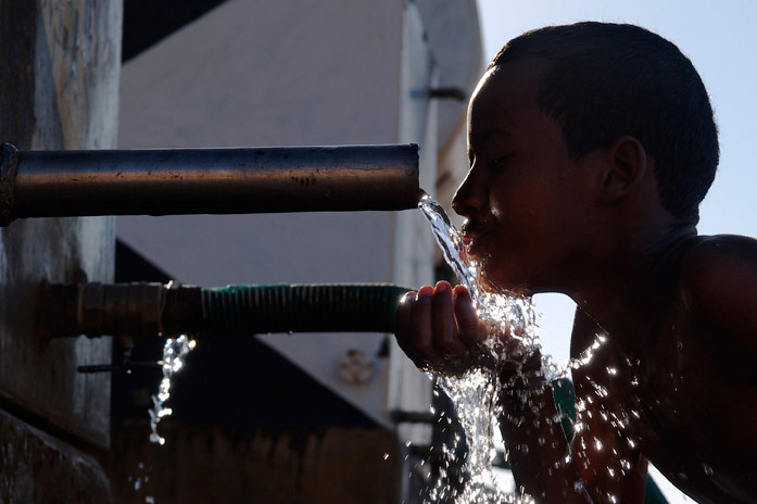 Un niño bebiendo agua.