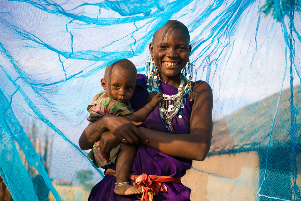 Una madre con su hijo bajo una mosquitera tratada con insecticida en Arusha, Tanzania. Foto: UNICEF/Hallahan