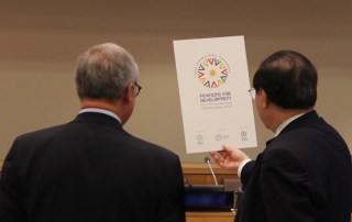Wu Hongbo, UN Under-Secretary-General for Economic and Social Affairs, and a colleague admire the new Financing for Development Conference logo. Photo: UNDESA.