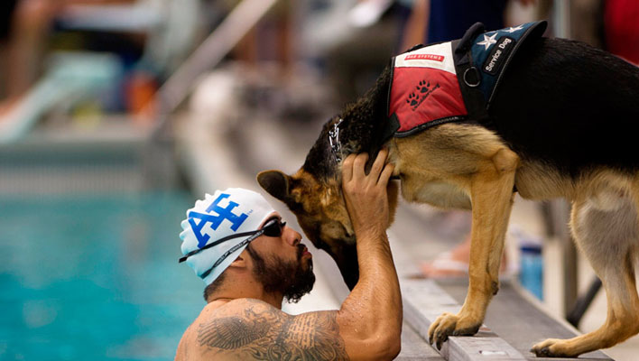 Un nageur caressant son chien dans un bassin