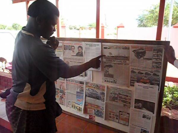 Okanguati Community member reading New Era on display board