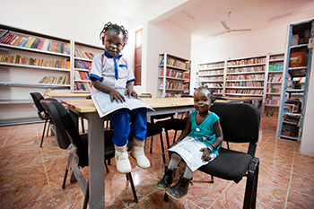 Xima Awada Yakub, 4 ans, et sa soeur Zamai, lisent des livres dans la bibliothèque du Centre culturel d'El Fasher (au Nord du Darfour) récemment restauré. Photo ONU/Albert González Farran