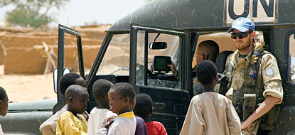 Un soldat de la paix avec des enfants soudanais réfugiés