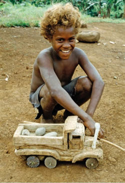 Young boy in Malaita, Solomon Islands, playing with his homemade wooden truck, 1987. UN Photo/W Stone.