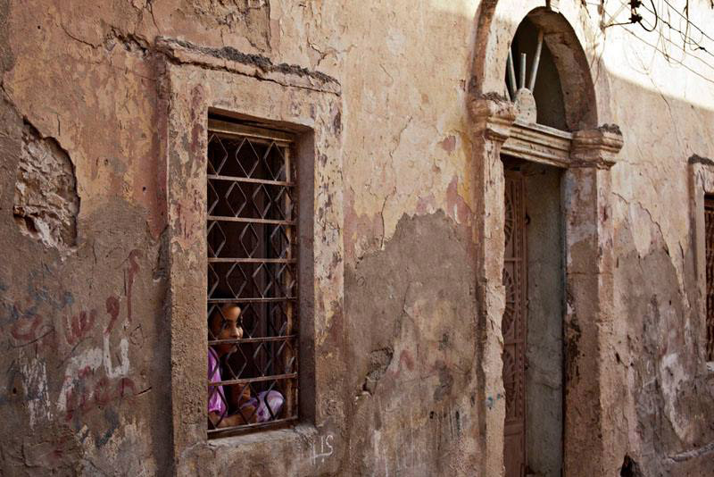 A girl looks out of her house window in Benghazi. Security Council condemned the ‘heinous’ bomb attacks in Libya.