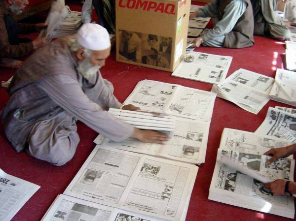 Hand collating the 'Kabul Weekly' newspaper