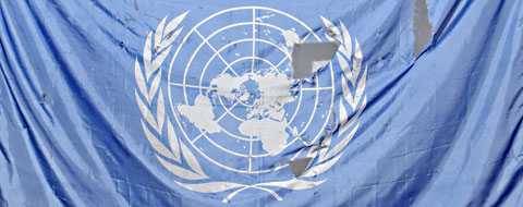 A UN flag damaged from a bomb blast.