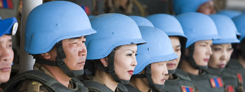 UN peacekeepers in a row wearing blue helmets.