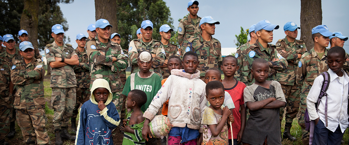 Uruguayan peacekeepers with the UN Organization Stabilization Mission in the Democratic Republic of the Congo (MONUSCO) and local youth watch a soccer game at the launching of a new soccer school they helped launch. UN Photo/Sylvain Leichti