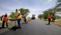 Workers take measurements while laying the tarmac on a new road being built near Arusha, Tanzania. Africa needs funds for such development projects. Panos/Frederic Courbet
