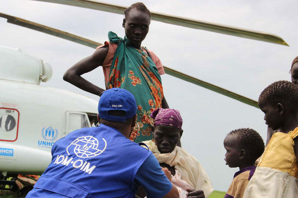 En novembre 2014, les équipes de l’Organisation internationale pour les migrations (OIM) aident à transporter des réfugiés vulnérables au moyen d’un hélicoptère du Haut-Commissariat pour les réfugiés (HCR) au Soudan du Sud. Photo : OIM