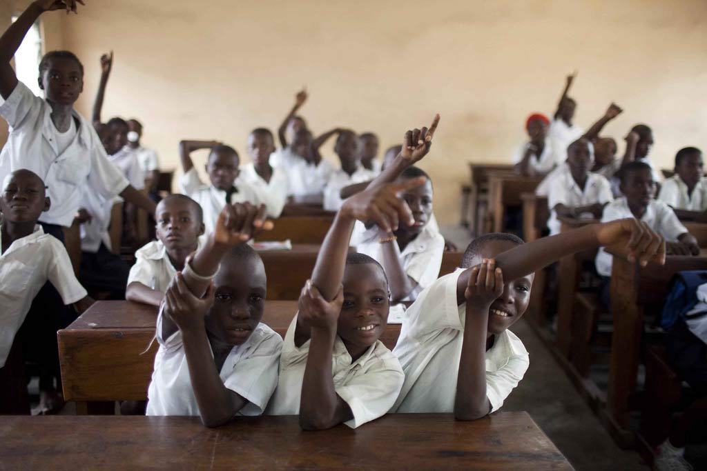 Students at a primary school in the Democratic Republic of the Congo (DRC) raise their hands to answer a class question. Photo: World Bank/Dominic Chavez