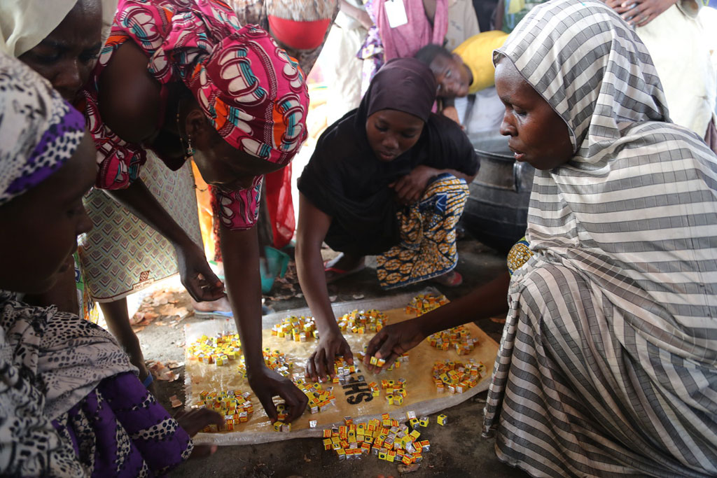 IDP women in one of the camps in Maiduguri, Borno State, Nigeria, collect their share of stock cubes to prepare the day