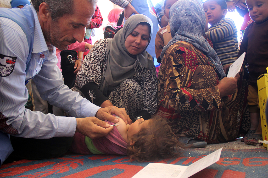 Health workers vaccinate a child in a medical centre in Al-Radwanieh village, rural Aleppo. Photo: UNICEF/ Al-Issa