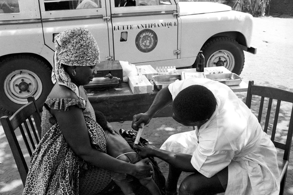 A technician vaccinates a small child, February 1964, in Togo, where the Government carried out an extensive anti-yaws campaign, assisted by experts from the World Health Organization. UNICEF supplied the equipment. UN Photo/BZ