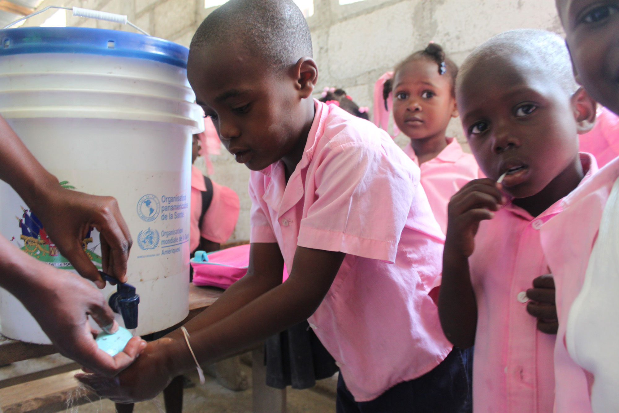 A group of Haitian children learn how to properly wash their hands in an effort to raise awareness about cholera prevention. UN Photo/ Logan Abassi