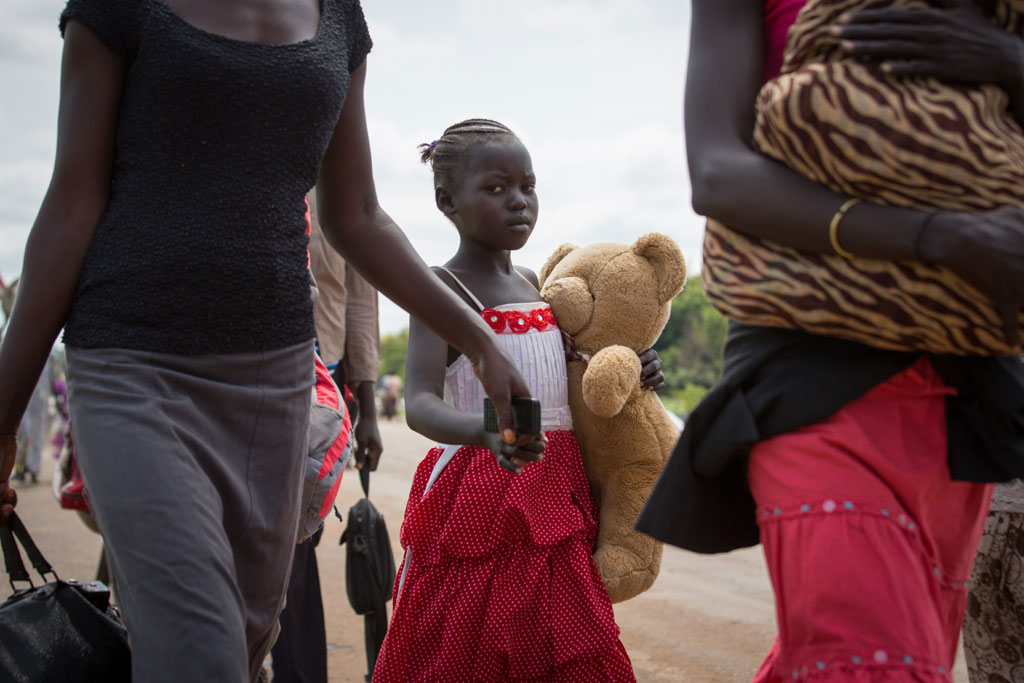 A young refugee and her family cross the border between South Sudan and Uganda. Photo: UNHCR/Will Swanson