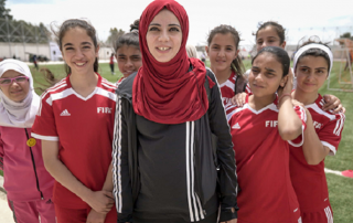 Syrian refugee and Jordanian girls participate in a mixed-nationality football camp in Jordan. Photo: UN Women/Christopher Herwig