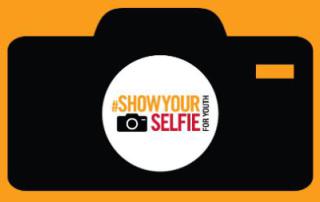 The "#ShowYourSelfie" campaign logo, which features the outline of a black camera on an orange background