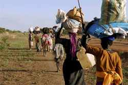 Descivils soudanais marchent en portant leurs bagages sur la tête