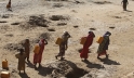 Women carry jerry cans of water from shallow wells dug from the sand along the Shabelle River bed, following a drought in Somalia. Photo: Reuters/Feisal Omar