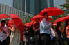 UN staff members holding open red umbrellas to form the AIDS ribbon