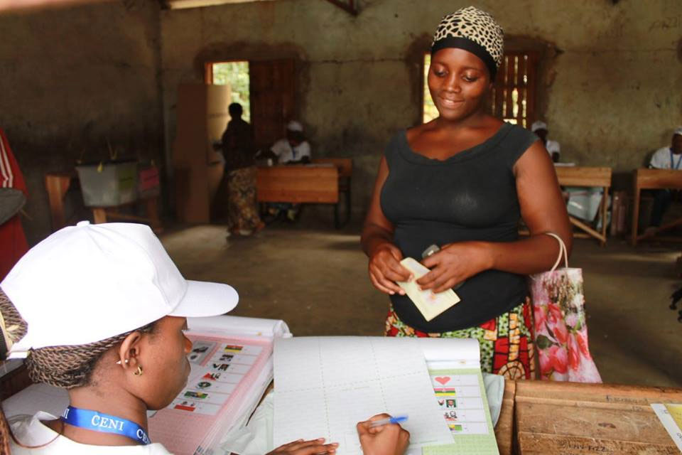 An electoral worker checks names against the voters&#039; list at a polling station during elections in Burundi. Photo: MENUB