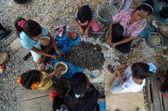 Una familia comiendo en el suelo. Foto OIT/Ferry Latief