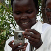 Godelieve toma una foto de Annociata que fotografía a otras mujeres. Annociata es una de las doce participantes del proyecto Imágenes de Rwanda. Es una superviviente del genocidio de 1994 y es asistida por Godelieve.
