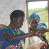 Xaverina lee la Biblia en el funeral de una joven de su comunidad que murió recientemente de malaria. Muchas personas consideran a Xaverina una líder de su comunidad por lo que le pidieron que oficiara este entierro.