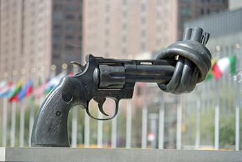 photo of a sculpture of a gun with the barrel twisted into a knot