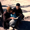 Street scene, adult teaching a child to read, reading