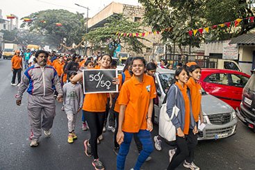 Youth dressed in orange marching against gender violence