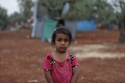 Syria. A girl stands near a makeshift camp near the border with Turkey.
