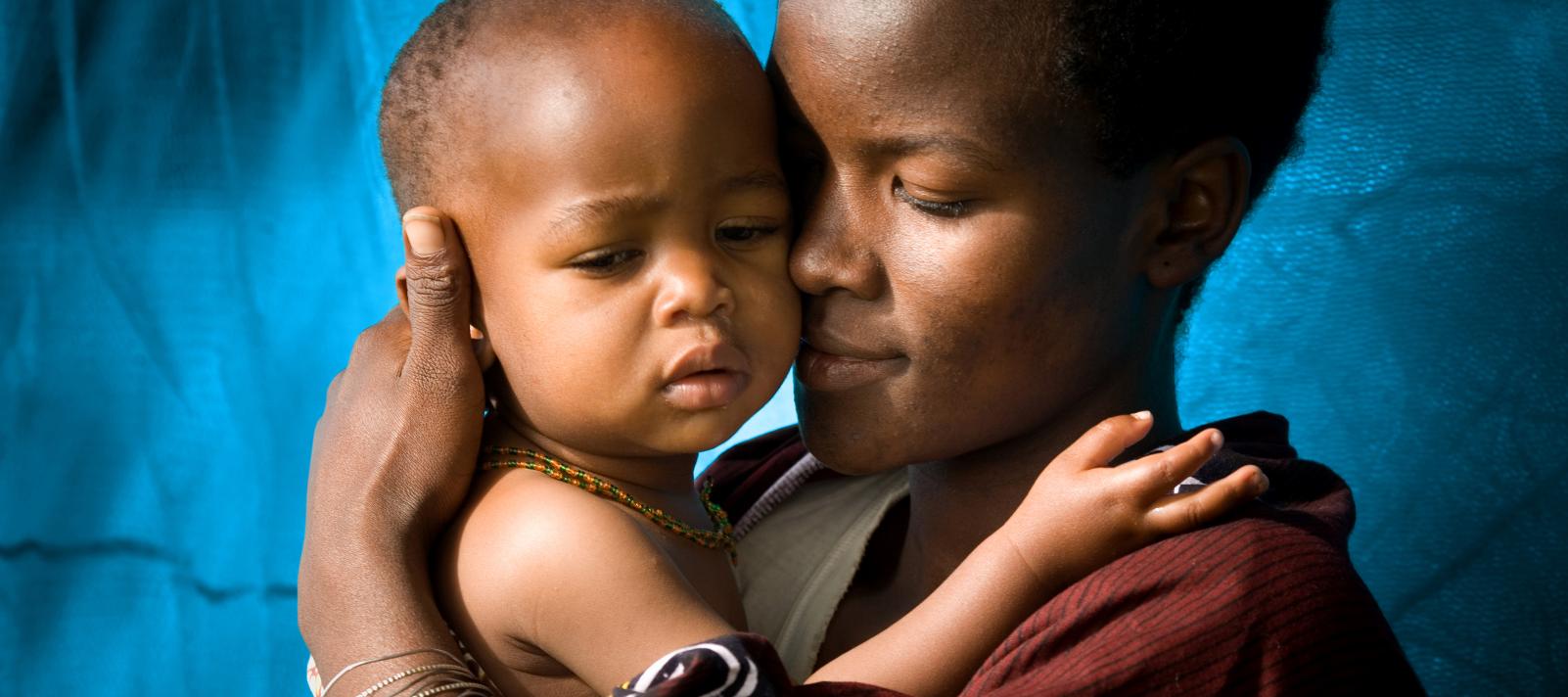 A mother holds her child to her face, Tanzania