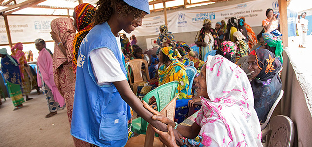 A humanitarian worker meets a women in a refugee camp in Cameroon. Photo: UN Women/Ryan Brown